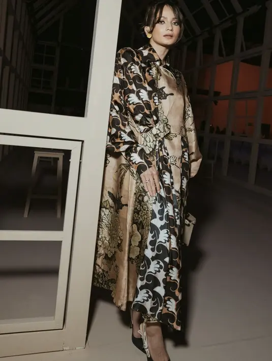 Menghadiri fashion show Biyam. Enzy tampak kenakan gaun mewah bernuansa gold. Aksen printed yang mewah hadirkan pesona sempurna pada tampilan. [Foto: instagram/ Enzy Storia]