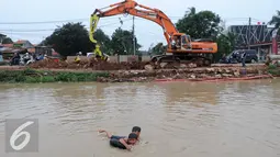 Dua orang anak berenang di sungai dekat pembangunan Proyek jalan tol bekasi-cawang-kampung melayu (Becakayu), Jakarta, (28/5) . Proyek tol yang sempat mangkrak ini terus dipercepat dan di targetkan akhir 2017 akan rampung. (Liputan6.com/Helmi Affandi)