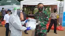 Penggali makam Covid-19 berbaju hazmat menerima donasi dari perwakilan Abituren Akmil 95 di TPU Pondok Rangon, Jakarta Rabu (20/5/2020). Donasi berupa 165 paket ditambah 60 paket APD, 250 masker Kain dan 100 face shield (Liputan6.com/Pool/Damadika 95)