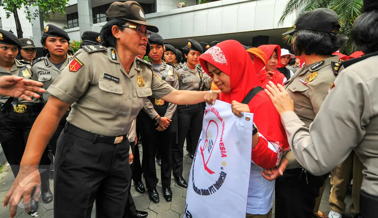 Seorang polwan berdialog dengan pendemo agar tidak menutup akses jalan ketika menggelar demonstrasi di depan gedung Kemenkes, Jakarta, Rabu (4/5). Para bidan desa berdemo menuntut diangkat menjadi pegawai tetap tanpa syarat.  (Liputan6.com/Yoppy Renato)