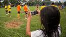 Seorang anak memotret latihan Arema Cronus jelang laga Torabika Soccer Championship 2016 melawan PS TNI di Lapangan Kostrad, Bogor, Jawa Barat, Sabtu (30/7/2016). (Bola.com/Vitalis Yogi Trisna)