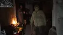 Seorang wanita tua bersiap untuk makan siang di ruang bawah tanah sebuah bangunan yang digunakan sebagai perumahan bagi sekitar 400 orang, karena apartemen digunakan oleh tentara Rusia selama pendudukan Bucha, di pinggiran Kyiv, Ukraina, Senin, 4 April 2022 (AP Photo/Rodrigo Abd)