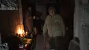 Seorang wanita tua bersiap untuk makan siang di ruang bawah tanah sebuah bangunan yang digunakan sebagai perumahan bagi sekitar 400 orang, karena apartemen digunakan oleh tentara Rusia selama pendudukan Bucha, di pinggiran Kyiv, Ukraina, Senin, 4 April 2022 (AP Photo/Rodrigo Abd)
