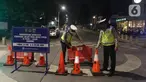 Polisi menyusun pembatas jalan di Jalan Kemang, Jakarta, Senin (21/6/2021). Penutupan jalan dalam rangka pembatasan mobilitas warga guna menekan penyebaran COVID-19 dilakukan mulai pukul 21.00 WIB hingga 04.00 WIB di 10 titik di Kota Jakarta. (Liputan6.com/Herman Zakharia)