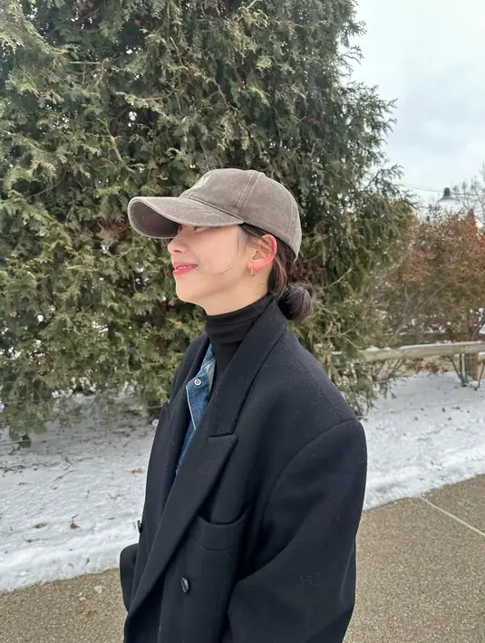 Di musim dingin, Karina padukan turtleneck berlapis jaket denim dan long coat hitam. Snapback abu-abu jadi sentuhan boyish yang simple [@katarinabluu]