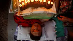 Tubuh seorang pemuja yang dipenuhi lampu minyak, dan sambil berdoa dalam upacara Dashian yang di gelar di Bhaktapur, Nepal (11/10).  Upacara Dashian merupakan sebuah acara besar di Nepal yang digelar 5 tahun sekali. (REUTERS/Navesh Chitrakar)