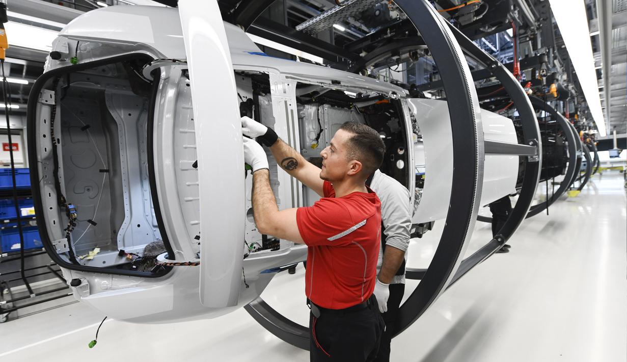 Mekanik melakukan pengecekan rangka mobil listrik Porsche Taycan saat proses perakitan di pabrik perusahaan Porsche AG di Stuttgart, Jerman, Rabu (4/3/2020). Porsche Taycan merupakan mobil bertenaga listrik pertama  dari pembuat mobil mewah Jerman, Porsche AG. (AFP Photo/Thomas Kienzie)