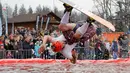 Seorang peserta mengenakan kostum sambil melakukan backflip sebagai bagian dari kompetisi komik 'Californication 9.0' di kota Logoisk, utara Minsk, Belarus, 7 April 2019. Sebanyak 8 peserta dengan kostum unik berseluncur salju untuk merayakan  akhir musim dingin. (AP Photo/Sergei Grits)