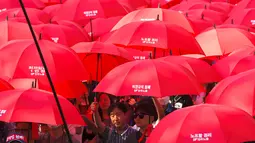 Serikat pekerja Korea Selatan membawa payung merah dalam pawai May Day di Seoul, Senin (1/5). Pekerja di berbagai belahan dunia mengadakan aksi Hari Buruh Internasional dengan memadati jalan-jalan besar untuk menyuarakan aspirasi. (JUNG Yeon-Je/AFP)