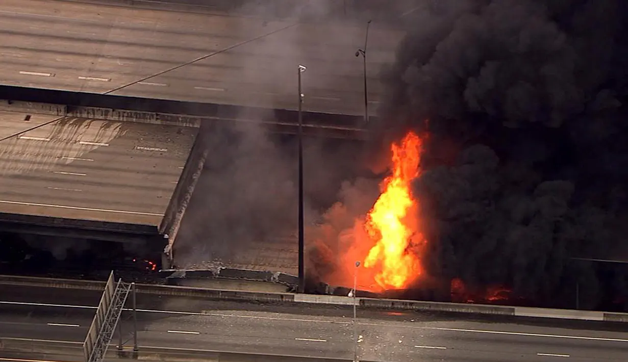 Kebakaran hebat yang terjadi di kolong jembatan layang Interstate-85 di Atlanta, Negara Bagian Georgia, Amerika Serikat (AS), menyebabkan ruas jalan tol itu runtuh, Kamis (30/3). Jembatan layang itu dikenal sebagai jalur tersibuk di AS. (WSB-TV via AP)