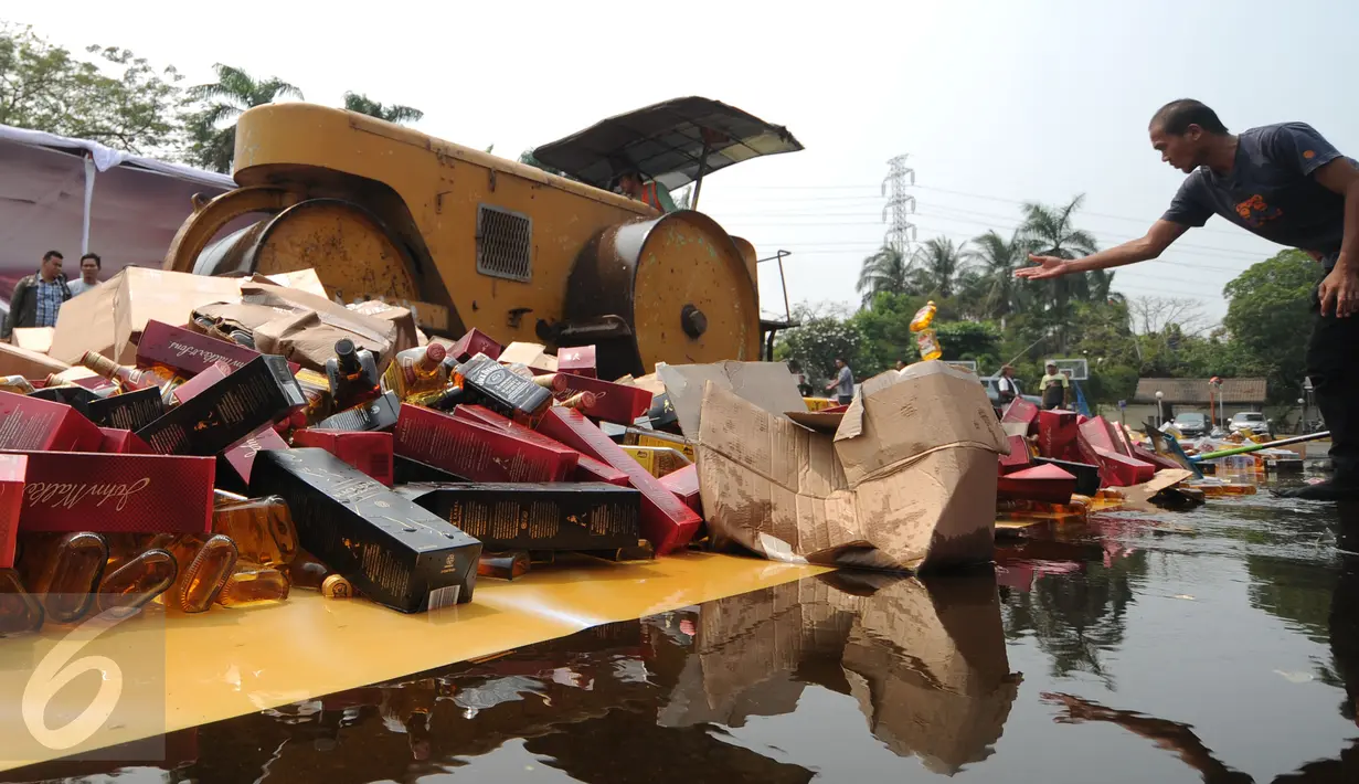 Petugas melempar botol minuman keras hasil sitaan Kantor Wilayah Bea Cukai Jakarta, Selasa (6/10/2015). Ditjen Bea Cukai berhasil menyita 12.967 botol miras dan dua juta batang rokok illegal serta 57 drum Etil Alkohol. (Liputan6.com/Helmi Fithriansyah)
