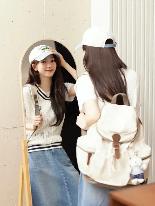 Karina aespa kenakan sleeveless sweater yang bikin t-shirt putihnya lebih advance. Dipadu dengan rok denim dan backpack putih [@katarinabluu]