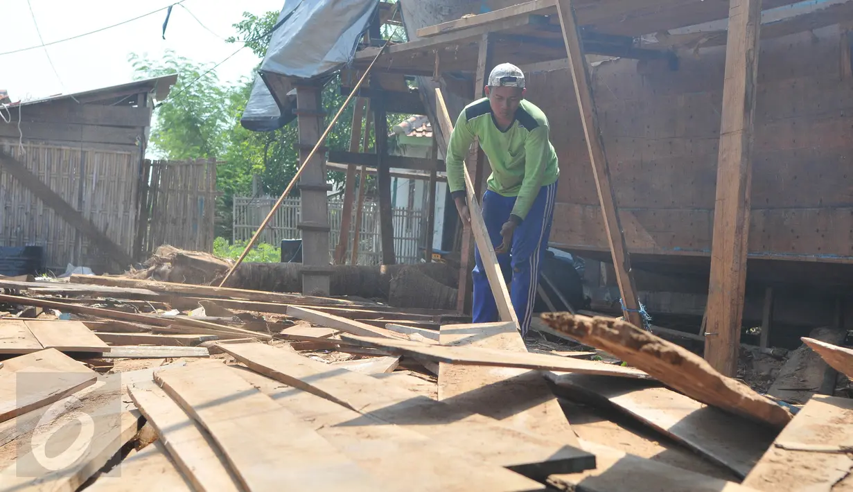 Pekerja memilih kayu untuk proses pembuatan kapal nelayan di Karangsong, Indramayu, Jawa Barat, Rabu (17/6). Pembuatan kapal berkapasitas sekitar 30 grosstone tersebut dapat memakan waktu 3-6 bulan. (Liputan6.com/Herman Zakharia)