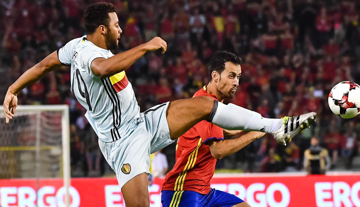 Gelandang Belgia, Mousa Dembele, berebut bola dengan gelandang Spanyol, Sergio Busquets. Spanyol berhasil melepaskan empat tendangan ke arah gawang, sementara Belgia hanya sekali. (AP/Geert Vanden Wijngaert)