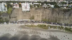 Para pengunjung berjemur dalam pembatas untuk menghindari keramaian di tengah pandemi COVID-19 di Pantai Lima, Peru, Rabu (21/12/2021). Di pantai-pantai populer di Lima, pihak berwenang memutuskan membuat pembatas untuk mencegah kerumunan pengunjung. (Ernesto BENAVIDES/AFP)