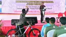 Seorang warga melambaikan tangan ke Presiden Jokowi usai mendapat hadiah sepeda dalam HPN 2018 di Padang, Sumatera Barat, Jumat (9/2). (Liputan6.com/Pool/Biro Setpres)