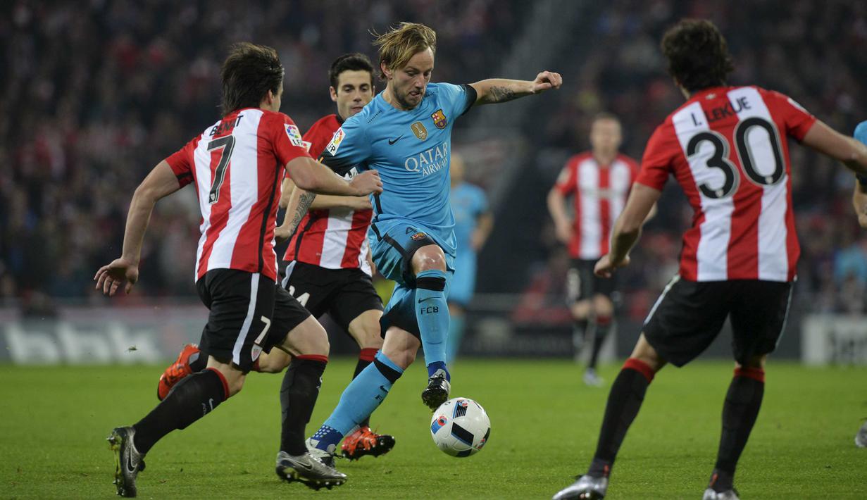 Athletic Bilbao, Benat Etxebarria (kiri) dan Inigo Lekue (kanan) mencoba menghadang pemain Barcelona, Ivan Rakitic pada Leg pertama perempat final Copa Del Rey di Stadion San Mames, Bilbao, Spanyol , Kamis (21/1/2016) dini hari WIB. (REUTERS/Vincent West)
