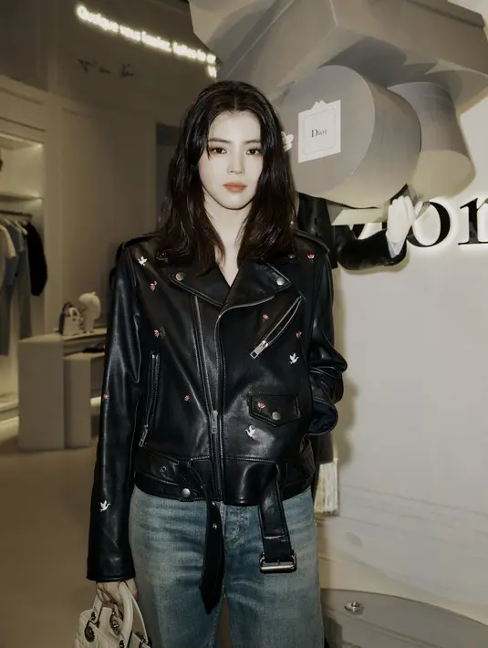Han So Hee curi perhatian dengan gaya lady biker yang rebel namun tetap elegan. Ia mengenakan biker jacket dengan celana jeans dan tas Lady Dior [Dior]