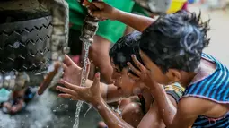 Anak-anak membersihkan diri dengan air bersih beberapa hari setelah bencana banjir yang dipicu oleh Topan Vamco di Marikina City, Filipina, pada 19 November 2020. Dunia merayakan Hari Anak Sedunia tahun ini pada Jumat (20/11). (Xinhua/Rouelle Umali)