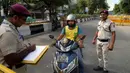 Seorang polisi mencatat detail seorang pengendara skuter yang memasuki zona terlarang menjelang KTT G20 di New Delhi, India, 8 September 2023. (AP Photo/Manish Swarup)