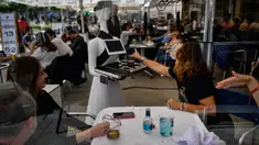 Sebuah robot yang dikenal sebagai "Alexia" menyajikan minuman kepada pengunjung sebuah bar di alun-alun Plaza del Castillo, di Pamplona, Spanyol pada 5 Juni 2020. Robot tersebut digunakan untuk mengurangi penyebaran virus corona Covid-19. (AP Photo/Alvaro Barrientos)