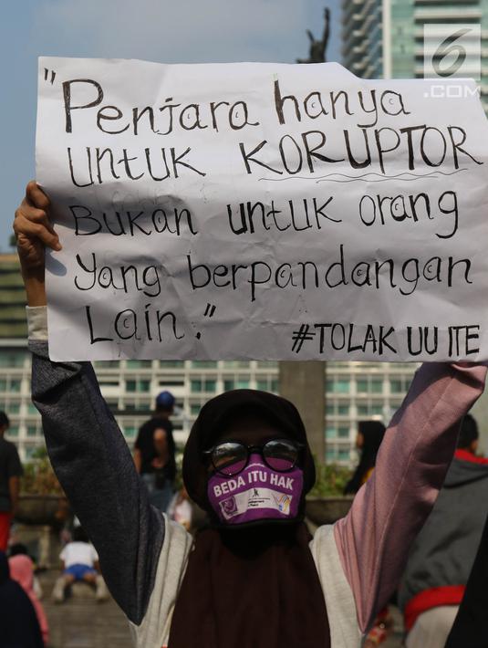 Jurnalis yang tergabung dalam Aliansi Jurnalis Independen (AJI) menunjukkan poster saat menggelar aksi menuntut pencabutan status tersangka Dandhy Dwi Laksono pada Car Free Day di Kawasan Bundaran HI, Jakarta, Minggu (29/9/2019). (Liputan6.com/Herman Zakharia)