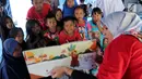 Anak-anak korban gempa tsunami Palu mendengarkan cerita bergambar di halaman kantor Dinas Sosial Palu, Sulawesi Tengah, Sabtu (6/10). Trauma healing diberikan untuk mencegah anak memiliki kepribadian buruk. (Liputan6.com/Fery Pradolo)