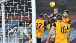 Striker Burnley, Ashley barnes (tengah), menyundul bola yang menghasilkan gol pertama timnya ke gawang Wolverhampton Wanderers dalam laga lanjutan Liga Inggris pekan ke-14 di Turf Moor Stadium, Senin (21/12/2020). Burnley menang 2-1 atas Wolverhampton. (AFP/Peter Powell/Pool)