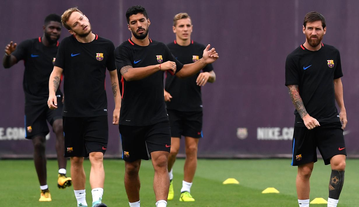 Lionel Messi (kanan), Luis Suarez (tengah) dan Ivan Rakitic (2kiri) melakukan pemanasa saat berlatih di Sports Center FC Barcelona Joan Gamper, Sant Joan Despi (15/8/2017). Barcelona kalah 1-3 pada leg pertama. (AFP/Lluis Gene)