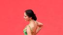 Beginilah gaya Raline Shah saat hadiri acara bergengsi dunia di red carpet Cannes 2022, Prancis. Tampak rambut yang disanggul memamerkan bahu dan punggungnya. Ia memakai gaun hijau glow in the dark rancangan Michael Cinco.