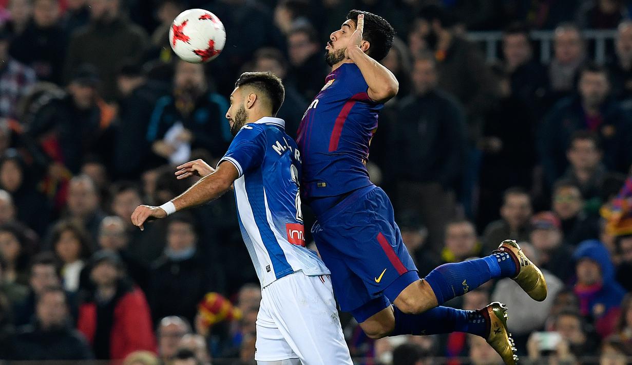 Pemain Barcelona Luis Suarez berebut bola dengan bek Spanyol Espanyol Marc Navarro pada laga leg kedua perempat final Copa del Rey di Camp Nou, Kamis (25/1). Barcelona memetik kemenangan dua gol tanpa balas atas lawannya. (AFP PHOTO/LLUIS GENE)