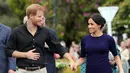 Pangeran Harry dan Meghan Markle berjalan di Taman Pemerintah Rotorua, Selandia Baru, Rabu (31/10). Pangeran Harry dan Meghan Markle sedang dalam tur tiga minggu di Australia, Selandia Baru, Tonga, dan Fiji. (Michael Bradley/Pool/AFP)