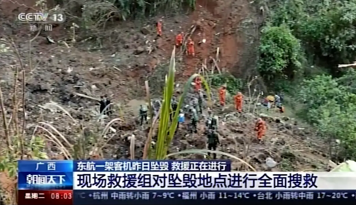 Tim penyelamat dan tentara melakukan operasi pencarian di lokasi kecelakaan pesawat maskapai China Eastern Airline di Tengxian, Daerah Otonomi Guangxi Zhuang, Selasa (22/3/2022). Barang yang ditemukan ada berupa dompet serta tanda pengenal di area kecelakaan pesawat. (CCTV via AP Video)