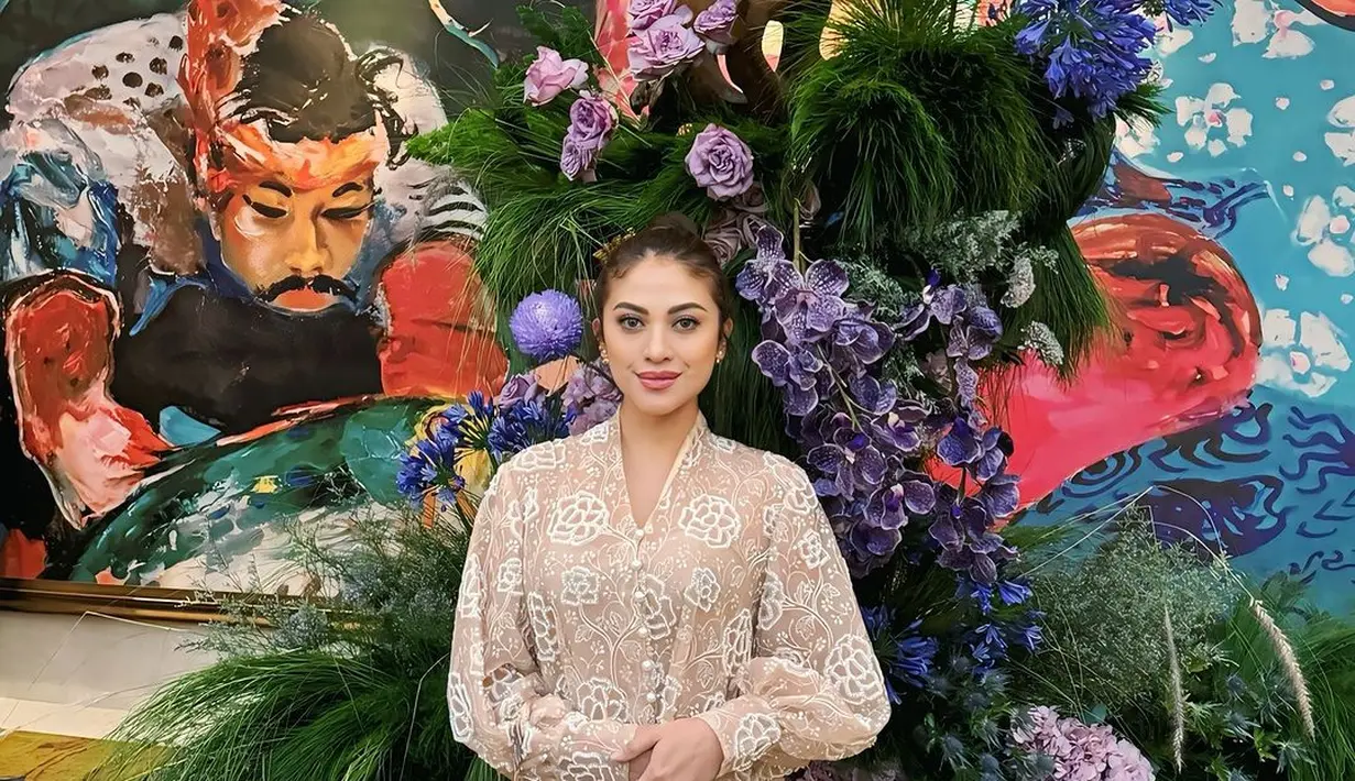 Cynthia Ganesha kenakan kebaya modifikasi dengan lengan puff dari koleksi terbaru Svarna. Atasan nude ini punya bordir monogram bunga dipadukan dengan celana putih [@cynthiaganesha]