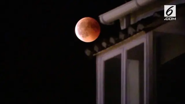 Seorang kameraman merekam gerhana "Blood Moon" terpanjang di abad ke langit malam Madrid, Spanyol, pada tanggal 27 Juli.