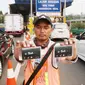 Petugas menunjukan kartu transaksi tol non tunai di gerbang tol Pejompongan, Jakarta, Jumat (15/9). Dalam menggunakan GTO ini, pengguna jalan tol diwajibkan memiliki kartu pembayaran non tunai sebagai kartu prabayar. (Liputan6.com/Angga Yuniar)