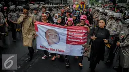 Sebuah spanduk bergambar bocah dibawa saat demo tolak Ahok di Jakarta, Rabu (21/9). Dalam aksinya mereka melakukan longmarch dari Raden Saleh menuju KPUD Jakarta. (Liputan6.com/Faizal Fanani)