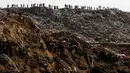 Sejumlah orang melihat proses evakuasi di lokasi longsoran sampah  di Tempat Pembuangan Akhir (TPA)  di Guatemala City, Guatemala, Rabu (27/4). Ribuan kubik sampah longsor dan menewaskan satu orang. (REUTERS/Josue Decavele)