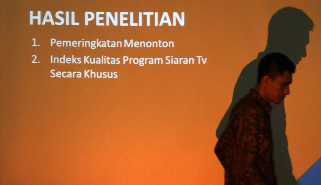 Seseorang melintas di depan proyektor jelang  rilis indeks kualitas program siaran televisi periode II 2016 di Jakarta, Rabu (5/10). Survei dilaksanakan tim dari ISKI dibantu 12 perguruan tinggi di Indonesia. (Liputan6.com/Helmi Fithriansyah)