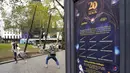 Orang-orang berpose di bawah tongkat raksasa untuk peringatan 20 tahun film Harry Potter and the Philosopher's Stone di Leicester Square, London, Rabu (13/10/2021). Instalasi terdiri dari sembilan tongkat setinggi 15 kaki yang mewakili sembilan karakter kunci dari film. (AP Photo/Alberto Pezzali)