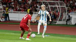 Pemain Timnas Argentina, Alejandro Garnacho (kanan), berusaha melewati hadangan pemain Timnas Indonesia, Asnawai Mangkualam dalam pertandingan FIFA Matchday 2023 yang berlangsung di Stadion Utama Gelora Bung Karno, Jakarta, Senin (19/6/2023). (Bola.com/Abdul Aziz)