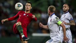 Cristiano Ronaldo, saat berebut bola dengan bek Luksemburg pada pertandingan kualifikasi Euro 2020 antara Portugal melawan Luksemburg di Stadion Jose Alvalade, Lisbon, 11 Oktober 2019. (AFP/Carlos Costa)