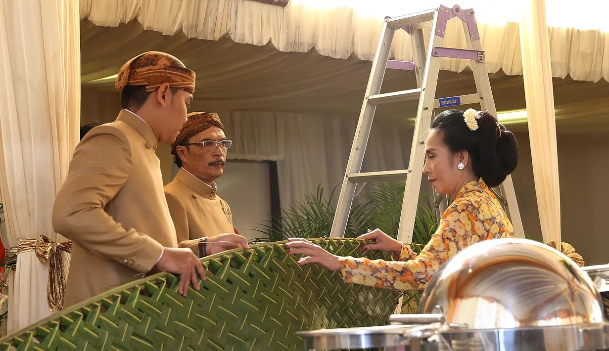 Ayah dan ibunda Selvi Ananda dalam prosesi pemasangan daun kelapa dalam acara pemasangan bleketepe.   (Galih w. Satria/bintang.com)
