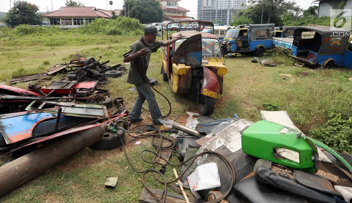 Pekerja memusnahkan bemo hasil razia di sejumlah wilayah di Jakarta, di pool Rawa Buaya, Cengkareng, Jakarta Barat, Selasa (1/8). Pemusnahan dilakukan, dikarenakan sejak 6 Juni 2017, Dishub DKI melarang bemo beroperasi. (Liputan6.com/Johan Tallo)