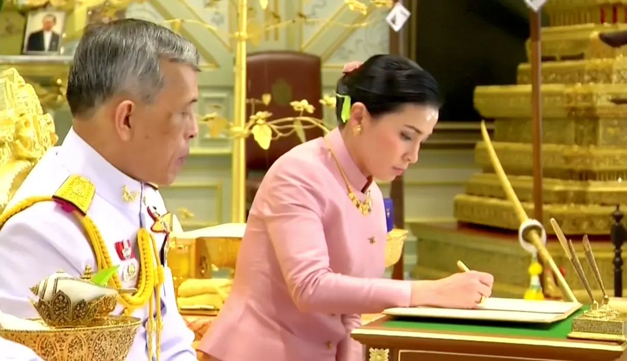 Ratu Suthida menandatangani dokumen pernikahannya dengan Raja Maha Vajiralongkorn saat melangsungkan prosesi pernikahan di Bangkok, Thailand, Rabu (1/5/2019). Ratu Suthida adalah pasangan Raja Vajiralongkorn dan telah terlihat bersama di depan publik selama bertahun-tahun. (Thai TV Pool via Reuters)