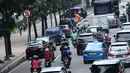 Pengendara motor melintas di sisi mobil parkir di jalur khusus motor di sekitar Jalan Medan Merdeka Barat, Jakarta, Kamis (1/3). Jalur yang seharusnya digunakan untuk pengendara motor tersebut hingga kini belum steril. (Liputan6.com/Helmi Fithriansyah)
