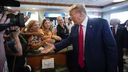 Mantan Presiden Amerika Serikat Donald Trump menyapa seorang pendukung saat dia mengunjungi Restoran Versailles di Miami, Amerika Serikat, Selasa (13/6/2023). Donald Trump singgah di sebuah restoran Kuba di Versailles usai menjalani sidang dakwaan terkait penanganan dokumen rahasia negara di Pengadilan Federal di Miami. (AP Photo/Alex Brandon)