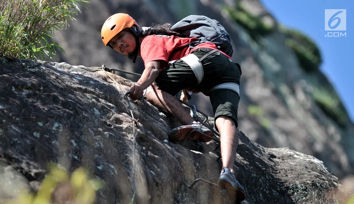 Pendaki memanjat tebing Gunung Parang via Jalur Ferrata, Desa Cihuni, Purwakarta, Jawa Barat, Sabtu (30/3). Gunung Parang merupakan gunung batu andesit tertinggi di Indonesia. (merdeka.com/Iqbal Nugroho)