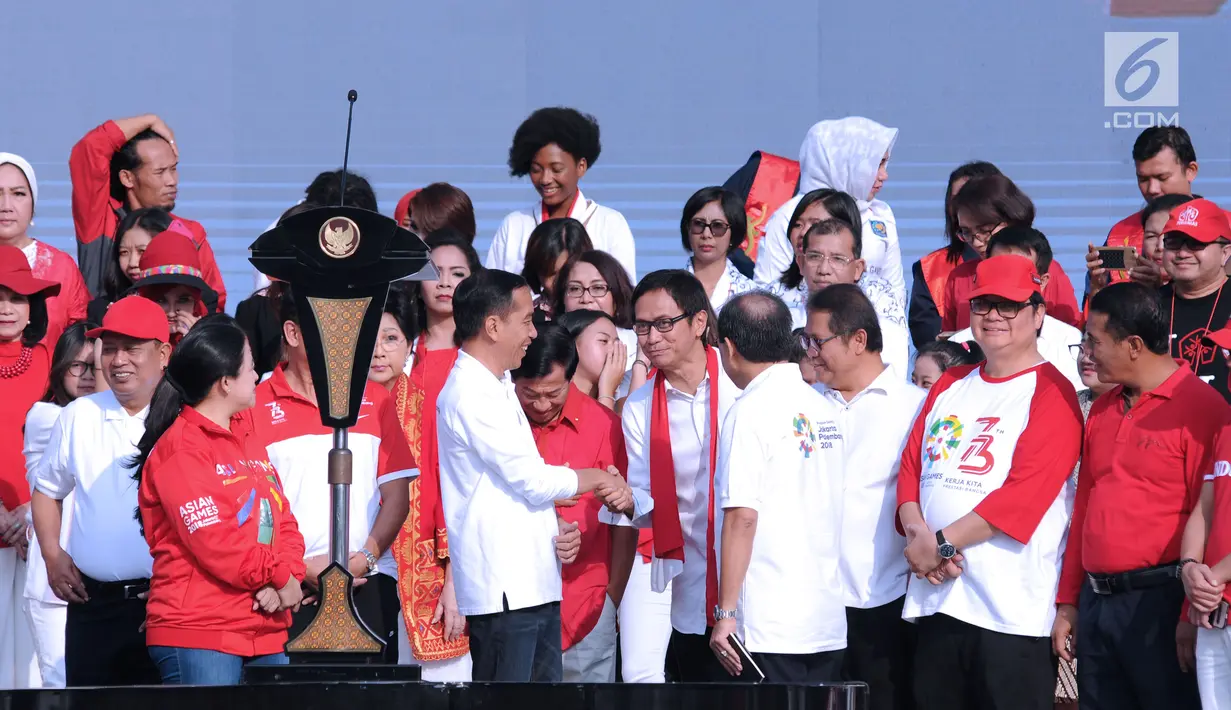 Presiden RI, Joko Widodo (tengah) menyalami konduktor Addie MS jelang bernyanyi bersama peserta Harmoni Indonesia 2018 di Kompleks Gelora Bung Karno, Jakarta, Minggu (5/8). Acara ini bagian perayaan HUT RI ke-73. (Liputan6.com/Helmi Fithriansyah)