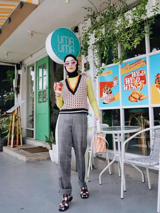 Kamu bisa banget sontek gaya nyentrik dengan memadukan vest, inner warna cerah seperti lime, pasmina, dan plaid pants. (Instagram/tantrinamirah).
